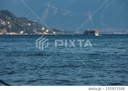 An evening view of the coastline of Vlora, Albania, taken in August 2025. Soft sunlight illuminates the rocky hills and seascape. An evening view of the coastline of Vlora, Albania, taken in August 2025. Soft sunlight illuminates the rocky hills and seascape. 135925388