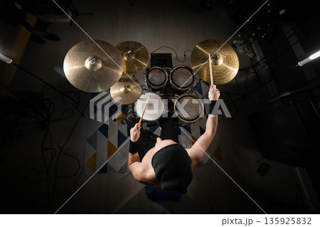 Drummer playing powerful rhythm on a professional drum kit 135925832
