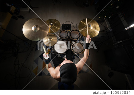 Drummer playing electronic drum kit performing music Drummer playing electronic drum kit performing music 135925834