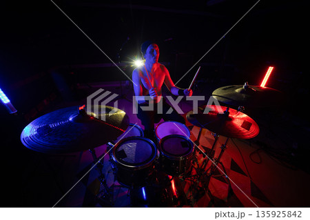 Drummer performing live music during vibrant stage show 135925842