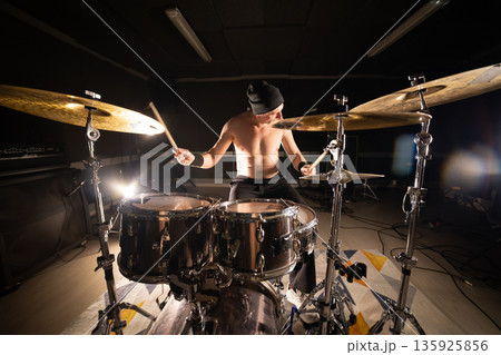 Energetic man drumming on stage creating rhythm 135925856