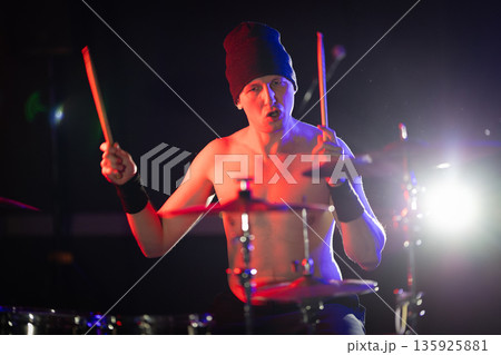 Male drummer playing drums performing live on stage Male drummer playing drums performing live on stage 135925881