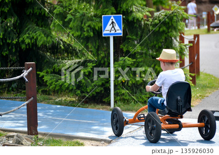 boy driving quad bike, four wheel cycle car, spring brightly morning, sunny day. High quality photo boy driving quad bike, four wheel cycle car, spring brightly morning, sunny day. High quality photo 135926030