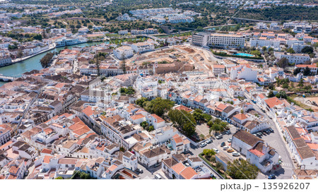 Tavira shows white houses and narrow streets from above, highlighting the town's layout, greenery, and surrounding hills on a clear day in Algarve, Portugal 135926207