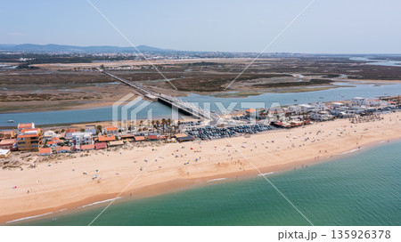 This aerial scene captures praia de Faro and new bridge in Portugal with the sandy beach, clear water, and a bridge connecting the land over a tranquil estuary This aerial scene captures praia de Faro and new bridge in Portugal with the sandy beach, clear water, and a bridge connecting the land over a tranquil estuary 135926378