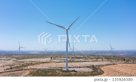 Wind green energy. Wind turbines stand tall against a clear blue sky, showcasing renewable energy potential and ecological innovation for a sustainable future Wind green energy. Wind turbines stand tall against a clear blue sky, showcasing renewable energy potential and ecological innovation for a sustainable future 135926380
