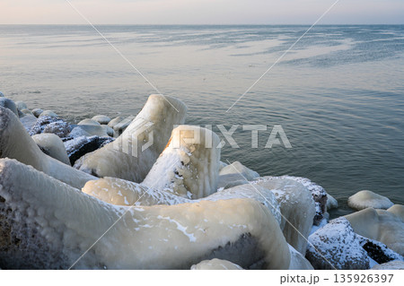 Ice-covered breakwater rocks on the Baltic Sea coast in Liepaja during a calm winter morning 135926397