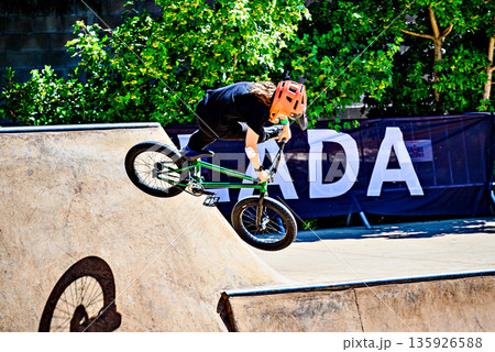 A young man practicing BMX and performing tricks at the skatepark. A young man practicing BMX and performing tricks at the skatepark. 135926588