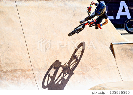 A young man practicing BMX and performing tricks at the skatepark. A young man practicing BMX and performing tricks at the skatepark. 135926590
