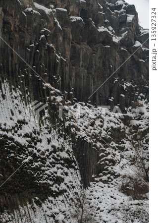 Snow-covered basalt columns form dramatic vertical patterns at the Symphony of Stones, dark volcanic rock contrasts with white winter textures Snow-covered basalt columns form dramatic vertical patterns at the Symphony of Stones, dark volcanic rock contrasts with white winter textures 135927324