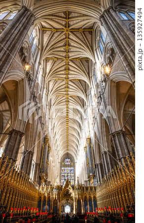 Visitors walk under the tall ceilings of Westminster Abbey in London. The light shines through tall windows, highlighting the intricate design. This location hosts many important events. Visitors walk under the tall ceilings of Westminster Abbey in London. The light shines through tall windows, highlighting the intricate design. This location hosts many important events. 135927494