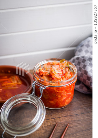 Fermented cabbage. Kimchi. Korean food in jar on wooden table. Fermented cabbage. Kimchi. Korean food in jar on wooden table. 135927557