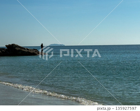 Lonely Fisherman on Rocky Seashore Lonely Fisherman on Rocky Seashore 135927597