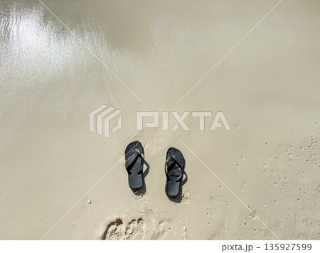 Flip Flops on Wet Sandy Beach Flip Flops on Wet Sandy Beach 135927599