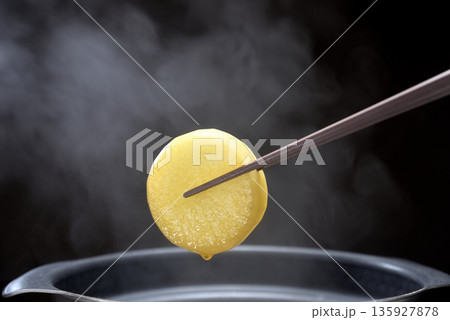 湯気の立ち昇る鍋で大根を茹でる 135927878