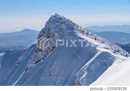厳冬期の谷川岳 オキの耳から見るトマの耳と登山者のシルエット 135928136