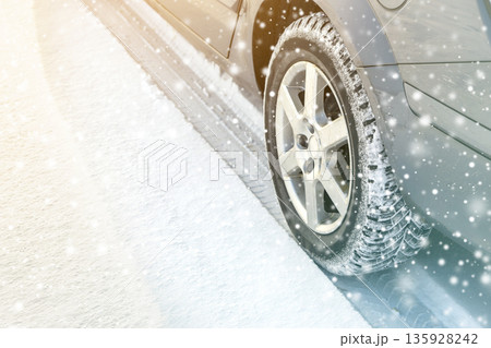 Close-up of car wheels rubber tires in deep winter snow. Transportation and safety concept. 135928242
