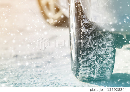 Close-up of car wheels rubber tires in deep winter snow. Transportation and safety concept. 135928244