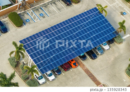 Sustainable power production integrated in urban infrastructure. Photovoltaic solar panels over car parking place for generation of renewable energy. 135928343