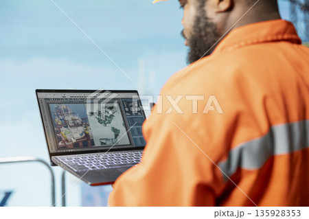 Close up of technician analyzing geological map to determine optimal offshore drilling locations. Drilling rig employee looking at global exploration data, selecting new well installation sites 135928353