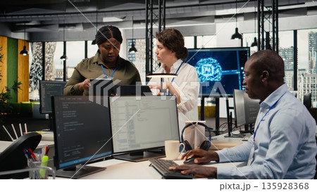 Female engineers in startup office using AI technology driving market innovation. Women working together in tech agency, applying machine learning to optimize operations and efficiency, camera A Female engineers in startup office using AI technology driving market innovation. Women working together in tech agency, applying machine learning to optimize operations and efficiency, camera A 135928368
