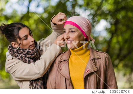 Daughter helping mother with headscarf, breast cancer awareness Daughter helping mother with headscarf, breast cancer awareness 135928708