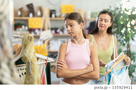 Teenage girl being capricious while shopping with mother in clothing store 135929411