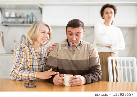 Family quarrel, old woman calming man 135929557