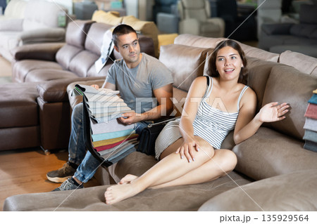 Man with his girlfriend are choosing modern materials for furniture for their home in furniture store 135929564