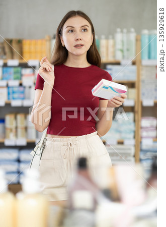Young woman customer choosing pills in box in drugstore Young woman customer choosing pills in box in drugstore 135929618