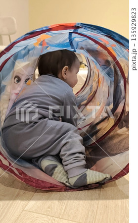 little boy playing at home crawling through play tunnel little boy playing at home crawling through play tunnel 135929823
