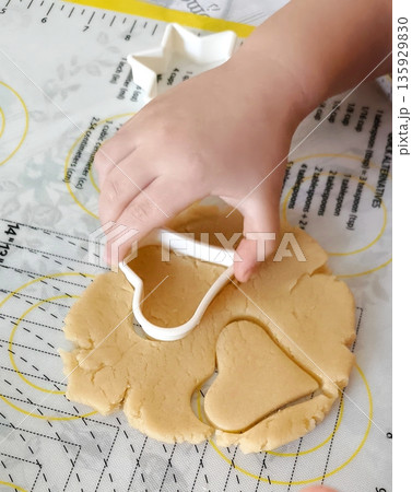 top view of children cutting gingerbread cookies from molds 135929830