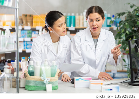 Two pharmacists working with computer in chemist's shop Two pharmacists working with computer in chemist's shop 135929838