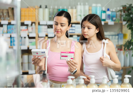 Mother with teenage daughter choosing pills 135929901