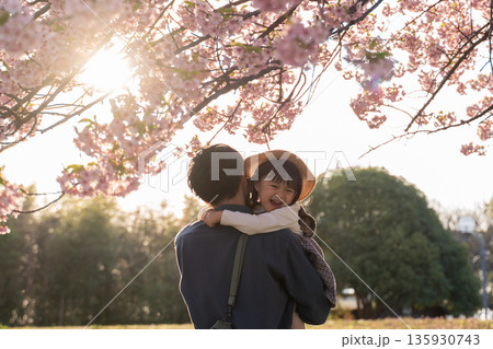 桜と夕焼けとハグする親子 135930743
