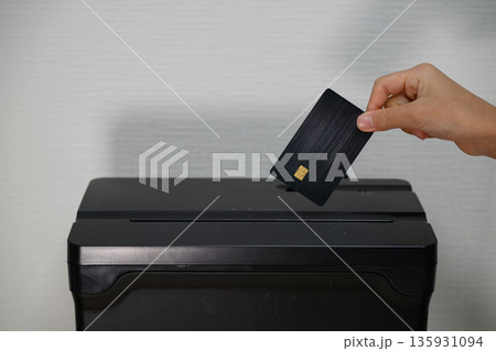 シュレッダーでクレジットカードを破棄する手元 シュレッダーでクレジットカードを破棄する手元 135931094