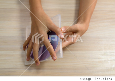 CDケースを開ける手元の俯瞰カット CDケースを開ける手元の俯瞰カット 135931373