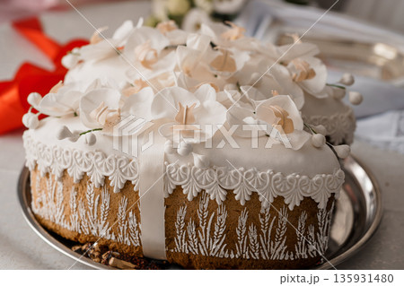 Elegant White Orchid-Covered Wedding Cake with Lace Trim and Wheat Design on Silver Platter Elegant White Orchid-Covered Wedding Cake with Lace Trim and Wheat Design on Silver Platter 135931480