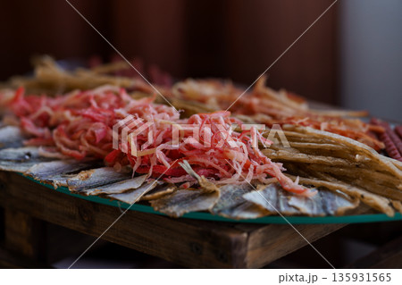 Freshly Sliced Pickled Vegetables and Dried Fish Arranged on a Wooden Platter with Vibrant Red and Golden Textures Freshly Sliced Pickled Vegetables and Dried Fish Arranged on a Wooden Platter with Vibrant Red and Golden Textures 135931565