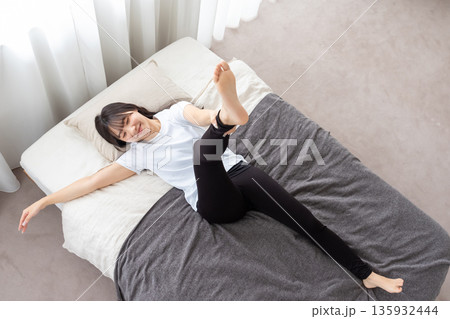 ベッドでストレッチをする女性 ベッドでストレッチをする女性 135932444