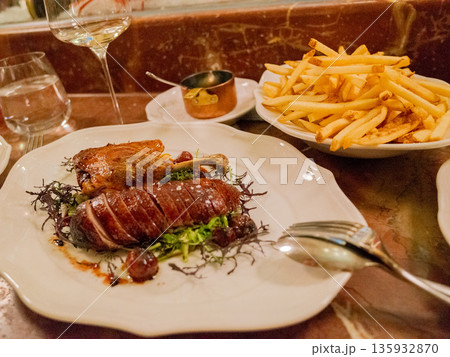 レストランで食べる鴨のローストと山盛りのフライドポテト 135932870