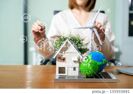 Confident eco expert holds globe and wind turbine model with digital overlays, promoting clean energy, carbon reduction, and future forward green technology. Confident eco expert holds globe and wind turbine model with digital overlays, promoting clean energy, carbon reduction, and future forward green technology. 135933691