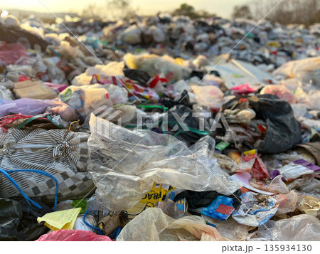 Large pile of plastic waste and garbage bags at an open dumpsite, highlighting plastic pollution, environmental damage, waste management problems, recycling crisis, sustainability issues, and global e Large pile of plastic waste and garbage bags at an open dumpsite, highlighting plastic pollution, environmental damage, waste management problems, recycling crisis, sustainability issues, and global e 135934130
