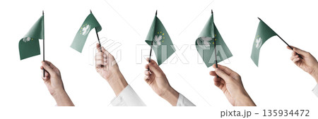 The Macao flag in hand in different angles on a white background The Macao flag in hand in different angles on a white background 135934472