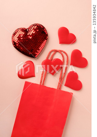 Red hearts spilling from shopping bag on pink background Red hearts spilling from shopping bag on pink background 135934842