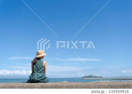 防波堤に座る女性 135934918
