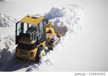 雪に覆われた駐車場を除雪する除雪車両 135935283