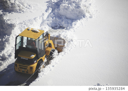 雪に覆われた駐車場を除雪する除雪車両 135935284