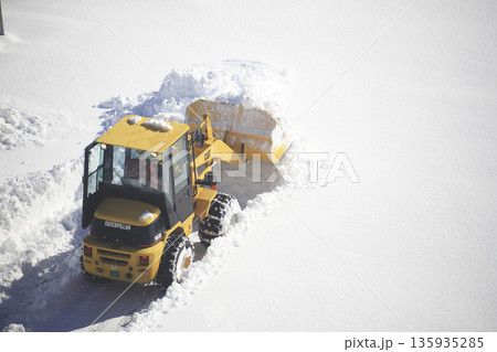 雪に覆われた駐車場を除雪する除雪車両 135935285