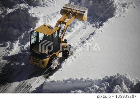 雪に覆われた駐車場を除雪する除雪車両 雪に覆われた駐車場を除雪する除雪車両 135935287